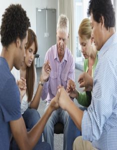 Meeting Of Bible Study Group Holding Hands And Praying.