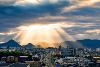 city with high rise buildings under white clouds during daytime