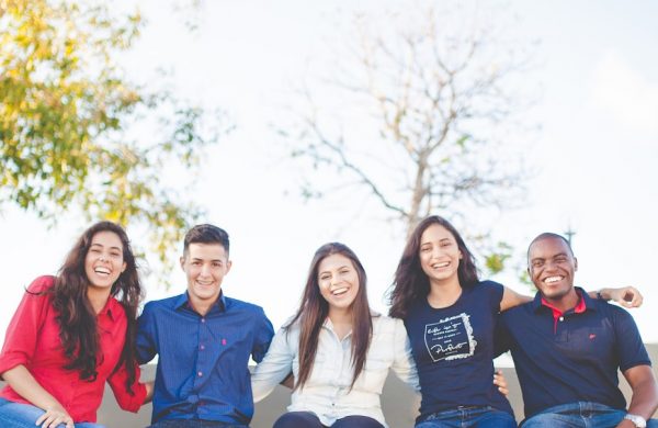 group of people sitting on bench near trees duting daytime